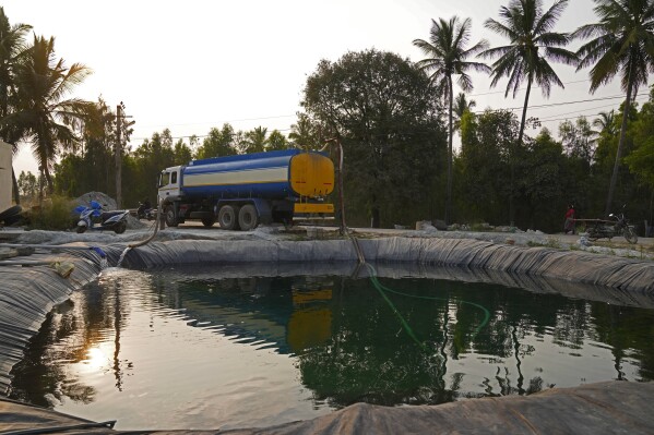 Potable water is loaded into a private water tanker from a temporary pond created to store groundwater later to be sold at high costs to offices and apartments, in Bengaluru, India, Monday, March 11, 2024. Water levels are running desperately low, particularly in poorer regions, resulting in sky-high costs for water and a quickly dwindling supply. (AP Photo/Aijaz Rahi)