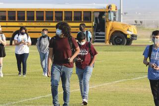 FILE — In this Sept. 17, 2020, file photo, students in face masks arrive on the Gila Ridge High School campus on the second first day of school, in Yuma, Ariz. School officials say several men threatened to make a citizen’s arrest of an Arizona school principal while at least one brandished cable ties in a confrontation over virus rules. Mesquite Elementary School's principal called police Thursday, Sept. 2, 2021, after she met with the men and they initially refused to leave. The arrest is the latest in a number of confrontations and other encounters in school settings over virus-related rules. (Randy Hoeft/The Yuma Sun via AP, File )