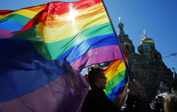 FILE - Gay rights activists carry rainbow flags as they march during a May Day rally in St. Petersburg, Russia, Wednesday, May 1, 2013. Russia’s Supreme Court on Thursday, Nov. 30, 2023, effectively outlawed LGBTQ+ activism, in the most drastic step against advocates of gay, lesbian and transgender rights in the increasingly conservative country. (AP Photo, File)