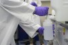 Logan Feeney pours a water sample with forever chemicals, known as PFAS, into a container for research, April 10, 2024, at a U.S. Environmental Protection Agency lab in Cincinnati. (AP Photo/Joshua A. Bickel, File)