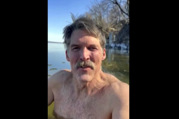 This screen shot from cell phone video provided by Eric Hovde’s campaign shows the candidate for U.S. Senate shirtless in the cold waters of Lake Mendota in Madison, Wis. on Thursday, Feb. 29, 2024. He was hoping to show he’s more of a hardy Wisconsinite than a soft Californian. He also challenged his Democratic challenger, U.S. Sen. Tammy Baldwin, to take a cold plunge as well. (Eric Hovde via AP)