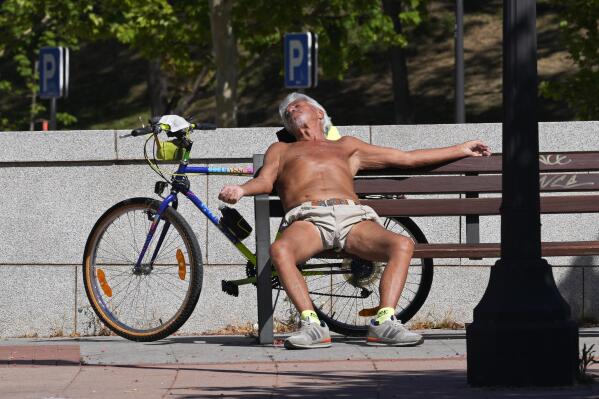 FILE - A man sunbathes on a hot spring day in Madrid, Spain, on April 18, 2023. Drought-stricken Spain says last month was the hottest and driest April since records began in 1961. The State Meteorological Agency, said Monday May 8, 2023 the average daily temperature in April was 14.9 degrees Celsius (58.8 Fahrenheit), that is 3 degrees Celsius above the average. (AP Photo/Paul White, File)