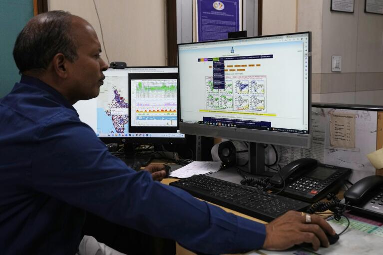 An employee at the India Meteorological Department looks at the different models for analysis and forecasting in New Delhi, India, Friday, March 17, 2023. The India Meteorological Department as well as the state of Kerala have increased infrastructure for cyclone warnings since Cyclone Ockhi in 2017, which killed about 245 fishermen out at sea. (AP Photo/Manish Swarup)