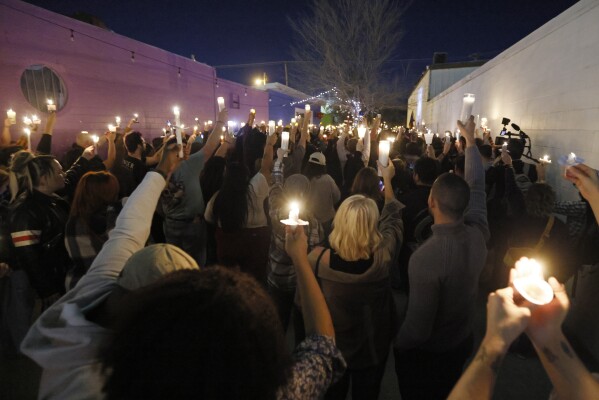 Hundreds of people hold up candles during a candlelight service for Nex Benedict, a nonbinary teenager who died one day after a fight in a high school bathroom, at Point A Gallery, Saturday, Feb. 24, 2024, in Oklahoma City. (Nate Billings/The Oklahoman via AP)