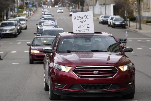 Motorist's participate during a drive-by rally to certify the presidential election results near the Capitol building in Lansing, Mich., Saturday, Nov. 14, 2020. Michigan's elections board is meeting to certify the state's presidential election results. (AP Photo/Paul Sancya)