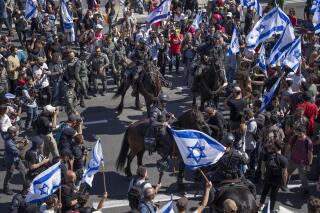 Israeli mounted police officers disperse demonstrators blocking a highway during a protest against plans by Prime Minister Benjamin Netanyahu's government to overhaul the judicial system in Tel Aviv, Israel, Thursday, March 16, 2023. (AP Photo/Oded Balilty)