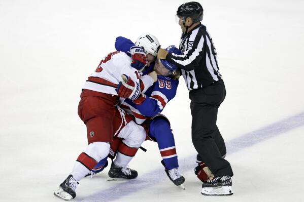 Linesman Jonny Murray tries to stop New York Rangers defenseman Ryan Lindgren (55) and Carolina Hurricanes center Max Domi from fighting after Game 3 of an NHL hockey Stanley Cup second-round playoff series, Sunday, May 22, 2022, in New York. (AP Photo/Adam Hunger)