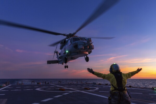 In this undated photo provided by the Australian Defence Force, a Seahawk helicopter prepares to land on the deck of HMAS Hobart during flying operations while on a regional presence deployment off northern Australia. Australia has protested to Beijing through multiple channels that a Chinese fighter jet endangered an Australian navy helicopter with flares over international waters, the prime minister said Tuesday, May 7, 2024. (LSIS Matthew Lyall/Australian Defence Force via AP)