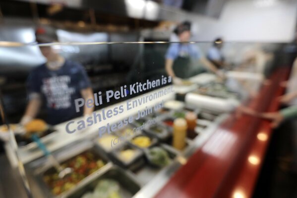 
              In this Tuesday, April 10, 2018, photo, employees prepare customers food at Peli Peli Kitchen in Houston. Owner Thomas Nguyen had a change of heart after transitioning one of his three Peli Peli South African fine dining restaurants and his Peli Peli Kitchen fast casual location to a no-cash policy. (AP Photo/David J. Phillip)
            