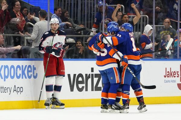 Columbus Blue Jackets' Andrew Peeke (2) watches the New York Islanders celebrate a goal by Mathew Barzal during the third period of an NHL hockey game Thursday, March 31, 2022, in Elmont, N.Y. The Islanders won 5-2. (AP Photo/Frank Franklin II)
