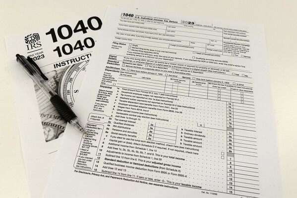 An Internal Revenue Service 2023 1040 tax form and instructions are shown on Friday, Jan. 26, 2024. For many people filing U.S. tax returns 鈥� especially those doing it for their first time 鈥� it can seem like a daunting task. (AP Photo/Peter Morgan)