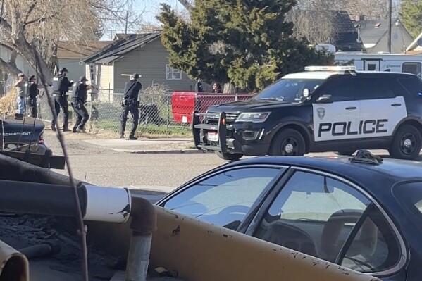 In this image made from video, police are seen shortly before opening fire on a teen on the other side of a fence Saturday, April 5, 2025, in Pocatello, Idaho. (Brad Andres via AP)