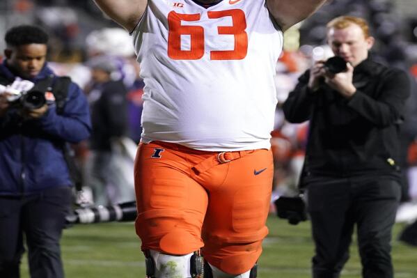 Illinois offensive lineman Alex Palczewski runs on the field with the Land of Lincoln Trophy after Illinois defeated Northwestern 41-3 in an NCAA college football game in Evanston, Ill., Saturday, Nov. 26, 2022. (AP Photo/Nam Y. Huh)