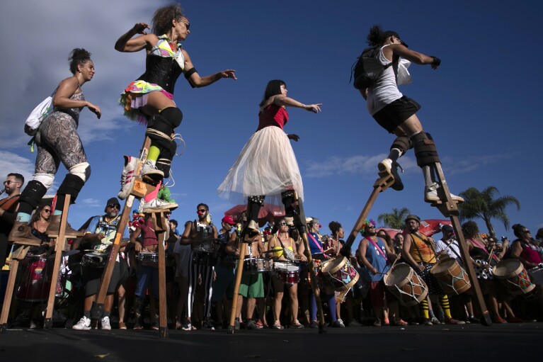 FILE - Revelers parade on wooden stilts during a pre-Carnival street party rehearsal, in Rio de Janeiro, Brazil, Jan. 21, 2024. A boom in stilt walking has altered the landscape of the world鈥檚 biggest Carnival, where hundreds of stilt walkers tower over the many raucous parties that occupy and dominate public areas. (AP Photo/Bruna Prado, File)
