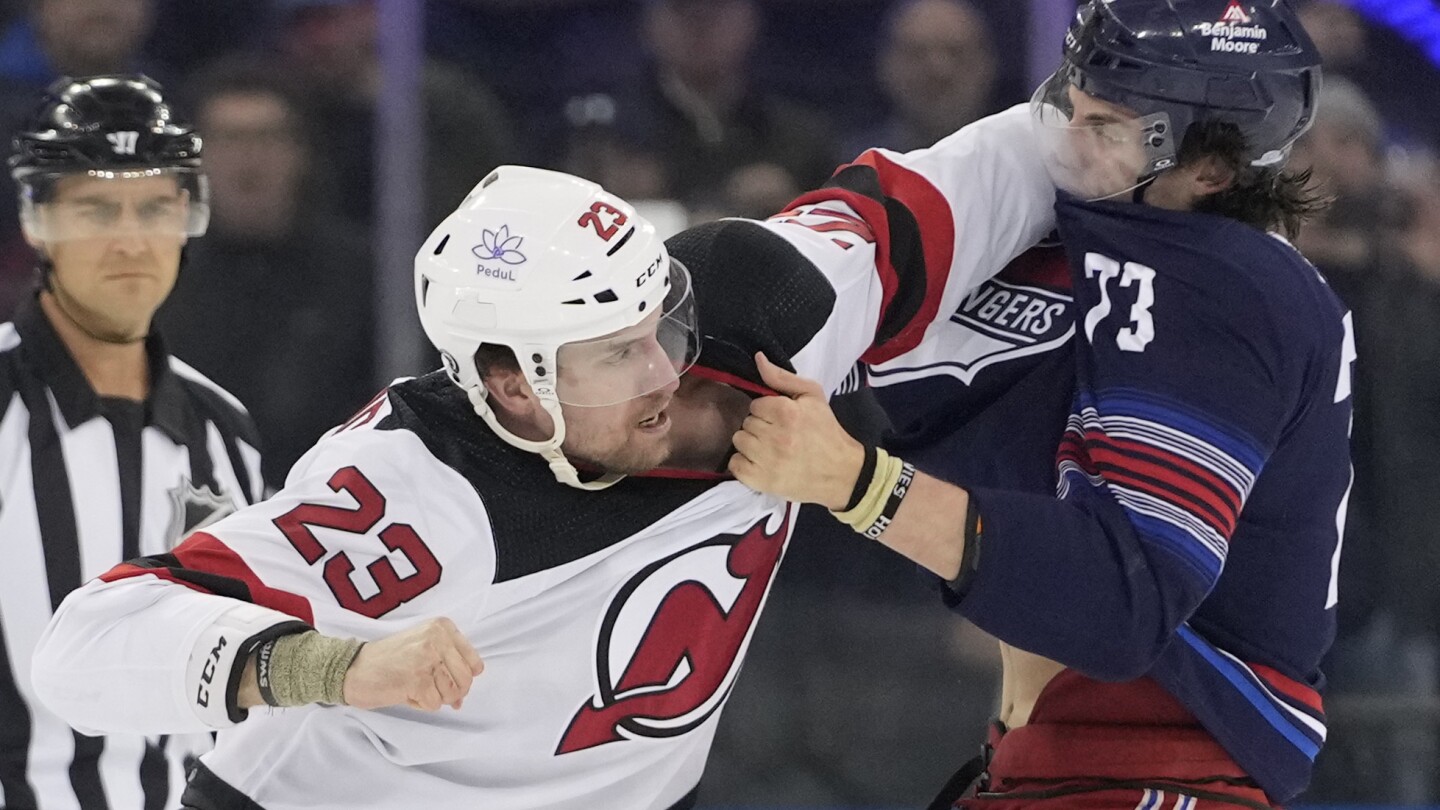 Tutti e 10 i pattinatori si danno da fare all'inizio della partita Devils-Rangers