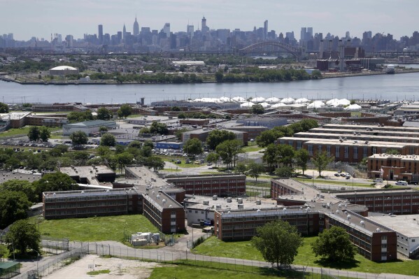 FILE - The Rikers Island jail complex stands with the Manhattan skyline in the background, June 20, 2014, in New York. A federal judge agreed Thursday, Aug. 10, 2023, to begin a process that could wrest control of New York City’s troubled jail system from Mayor Eric Adams and place a court-appointed outside authority in charge of Rikers Island. (AP Photo/Seth Wenig, File)