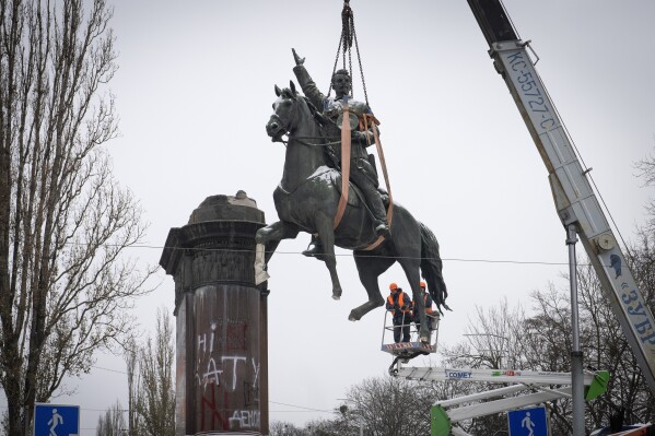 Municipal workers dismantle a monument to Soviet military leader Mykola Shchors in Kyiv, Ukraine, Saturday, Dec. 9, 2023. Shchors was a Ukrainian communist who fought with the Soviet army against Ukrainian independence following the 1917 Bolshevik revolution. Ukraine has accelerated efforts to erase the vestiges of centuries of Soviet and Russian influence from the public space since full-scale Russian invasion last February. (AP Photo/Efrem Lukatsky)