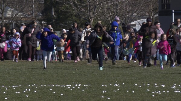 In this photo made from video, a child points to the sky, where a helicopter had dropped thousands of marshmallows to a park below in Southfield, Mich., on Friday, March 29, 2024. The annual Great Marshmallow Drop took place at Catalpa Oaks County Park in Southfield, Michigan, and was hosted by Oakland County Parks. (AP Photo/Mike Householder)