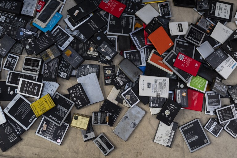 Used smartphone batteries for sale are scattered on a tarp in Nhat Tao market, the largest informal recycling market in Ho Chi Minh City, Vietnam, Sunday, Jan. 28, 2024. (AP Photo/Jae C. Hong)