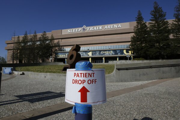 FILE - In this April 18, 2020, file photo, a temporary sign is placed at Sleep Train Arena that had been turned into a 400-bed emergency field hospital in Sacramento, Calif., to help deal with the coronavirus. When California was anticipating a spring surge in coronavirus cases it turned an old NBA arena and practice facility into a field hospital prepared to take hundreds of patients. They were told to expect 30 to 60 patients within the first few days, but only nine arrived over the next 10 weeks. (AP Photo/Rich Pedroncelli, File)