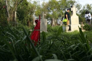 FILE - In this May 1, 2019, file photo, a stake is shown among gravestones that date back to the early 20th century at the Eli Jackson Cemetery in San Juan, Texas. The U.S. government says it won't build President Donald Trump's border wall on the site of the historic cemetery that might have required the exhumation of graves. U.S. Customs and Border Protection issued a statement Monday, June 3, 2019, saying it would "avoid" the Eli Jackson Cemetery while "still meeting Border Patrol's operational requirements for border wall." (AP Photo/Eric Gay, File)