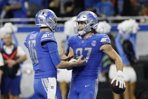 Detroit Lions quarterback Jared Goff (16) greets tight end Sam LaPorta (87) after LaPorta's 10-yard reception for a touchdown during the second half of an NFL football game against the Denver Broncos, Saturday, Dec. 16, 2023, in Detroit. (AP Photo/Duane Burleson)