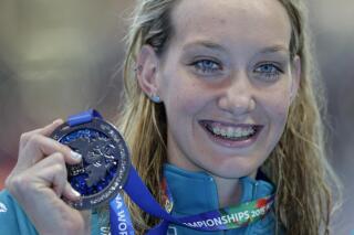 FILE - Australia's Madison Wilson holds her silver medal after her second place finish in the women's 100m backstroke final at the Swimming World Championships in Kazan, Russia, in this Tuesday, Aug. 4, 2015, file photo. Olympic gold medal swimmer Madison Wilson of Australia has been hospitalized for treatment of COVID-19. Wilson, who is fully vaccinated, was forced to withdraw from the International Swim League competition in Naples, Italy because of the diagnosis. “I’m taking some time to rest and I’m sure I’ll be ready to bounce back in no time,” Wilson said in a post Sunday, Sept. 19, 2021. (AP Photo/Michael Sohn, File)