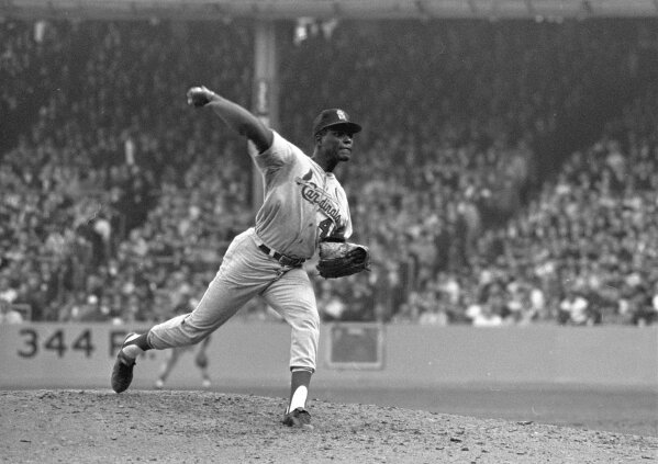 FILE - In this Oct. 12, 1964, file photo, St. Louis Cardinals pitcher Bob Gibson throws to a New York Yankees batter during Game 5 of the World Series, in New York. Gibson went all the way for a 5-2 win. Gibson, the dominating pitcher who won a record seven consecutive World Series starts and set a modern standard for excellence when he finished the 1968 season with a 1.12 ERA, died Friday, Oct. 2, 2020. He was 84. (AP Photo, File)