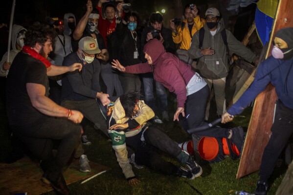 ARCHIVO - Manifestantes se enfrentan en un campamento en la UCLA la madrugada del miércoles 1 de mayo de 2024, en Los Ángeles. (AP Foto/Ethan Swope, Archivo)