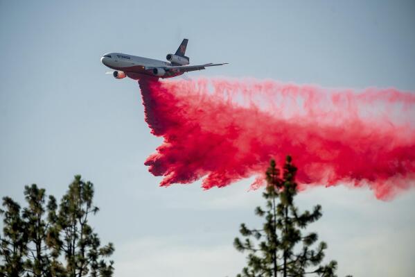 FILE - In this July 2, 2021, file photo a DC-10 air tanker drops retardant while battling the Salt Fire near the Lakehead community of Unincorporated Shasta County, Calif. Airport officials facing jet fuel shortages are concerned they'll have to wave off fire retardant bombers and helicopters when wildfire season heats up, potentially endangering surrounding communities. (AP Photo/Noah Berger, File)
