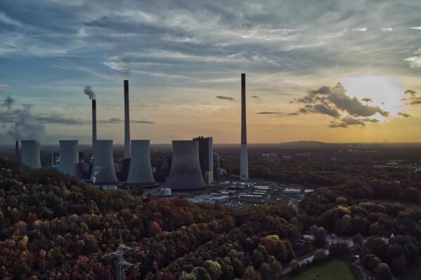 FILE - The sun sets behind the cole-fired power plant 'Scholven' of the Uniper energy company in Gelsenkirchen, Germany, Oct. 22, 2022. The European Union’s executive commission slashed its forecast for economic growth next year. It says that the 19 countries that use the euro currency will slide into recession over the winter as peak inflation hangs on for longer than expected and high fuel and heating costs erode consumer purchasing power. (AP Photo/Michael Sohn, File)