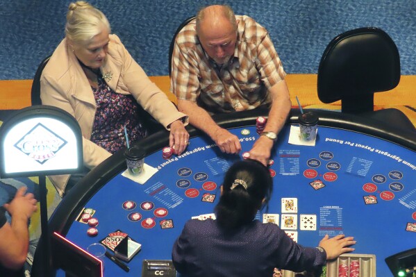 Gamblers play cards at the Ocean Casino Resort in Atlantic City, N.J., on Tuesday, May 21, 2024. New Jersey gambling regulators released figures Wednesday, May 22, 2024, showing the gross operating profit of Atlantic City's nine casinos declined by nearly 10% in the first quarter of this year. (AP Photo/Wayne Parry)