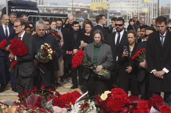 U.S. Ambassador to Russia Lynne Tracy, center, with other ambassadors of foreign diplomatic missions, attends a laying ceremony at a makeshift memorial in front of the Crocus City Hall on the western outskirts of Moscow, Russia, Saturday, March 30, 2024. (Sergei Ilnitsky/Pool Photo via AP)