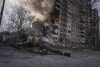 A Ukrainian police officer takes cover in front of a burning building in Avdiivka, Ukraine, Friday, March 17, 2023. The second year of Ukraine’s fight against Russia’s full-scale invasion brought no respite for Ukrainian soldiers or civilians. Associated Press photographers documented the past 12 months of death and destruction, agony and grief — as well as the glimpses of joy — that are staples of life during war. (AP Photo/Evgeniy Maloletka)