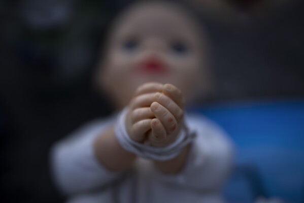 A baby doll symbolizing the small children who were abducted by Hamas militants during the group's Oct. 7 attack on Israel is displayed at a vigil for the victims in central Tel Aviv, Israel, Friday, Nov. 10, 2023. (AP Photo/Oded Balilty)