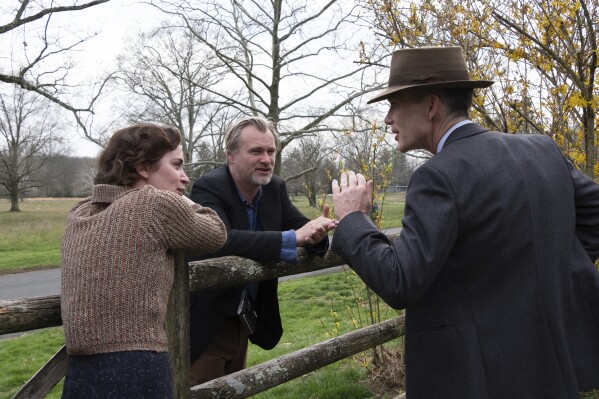 This image released by Universal Pictures shows actor Emily Blunt, left, with writer-director-producer Christopher Nolan, center, and actor Cillian Murphy on the set of "Oppenheimer." (Melinda Sue Gordon/Universal Pictures via AP)