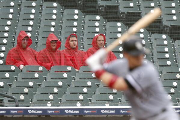 Fans watch Chicago White Sox's Yasmani Grandal bat as rain falls during the third inning of a baseball game against the Detroit Tigers on Tuesday, Sept. 21, 2021, in Detroit. (AP Photo/Duane Burleson)