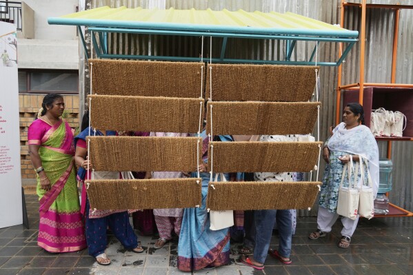 Daily wage workers, who mostly work outdoors, explore Neralu, an innovative portable heat shelter, at the Sweat and Concrete 2025 event in Bengaluru, India, Thursday, May 29, 2025. (AP Photo/Aijaz Rahi)