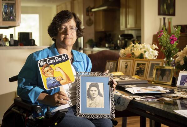 Dorene Giacopini holds up a photo of her mother Primetta Giacopini while posing for a photo at her home in Richmond, Calif. on Monday, Sept 27, 2021.  Primetta Giacopini's life ended the way it began — in a pandemic. She was two years old when she lost her mother to the Spanish flu in Connecticut in 1918. Giacopini contracted COVID-19 earlier this month. The 105-year-old struggled with the disease for a week before she died Sept. 16. (AP Photo/Josh Edelson)