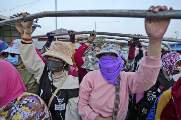 Cambodian garment workers stand on a back truck, wearing scarfs and caps to protect from the hot sun, after a day's work outside Phnom Penh Cambodia, Monday, April 29, 2024. (Ǻ Photo/Heng Sinith)