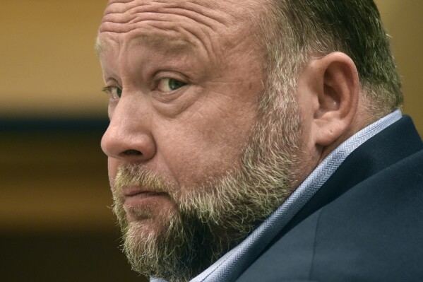 FILE - Infowars founder Alex Jones appears in court to testify during the Sandy Hook defamation damages trial at Connecticut Superior Court, Sept. 22, 2022, in Waterbury, Conn. Relatives of victims of the Sandy Hook Elementary School shooting are asking a bankruptcy judge to liquidate Jones' media company including Infowars instead of allowing him to reorganize his business, as they seek to collect on $1.5 billion in lawsuit verdicts against him. (Tyler Sizemore/Hearst Connecticut Media via AP, Pool, File)