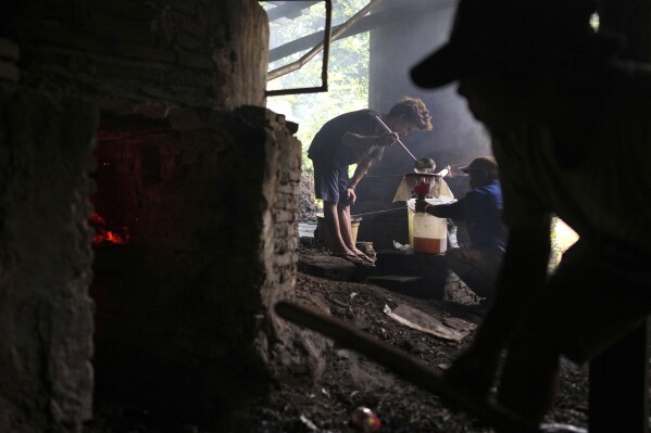 Workers filter patchouli oil at a refinery in Simboro, West Sulawesi, Indonesia, Wednesday, Feb. 26, 2025. (AP Photo/Dita Alangkara)