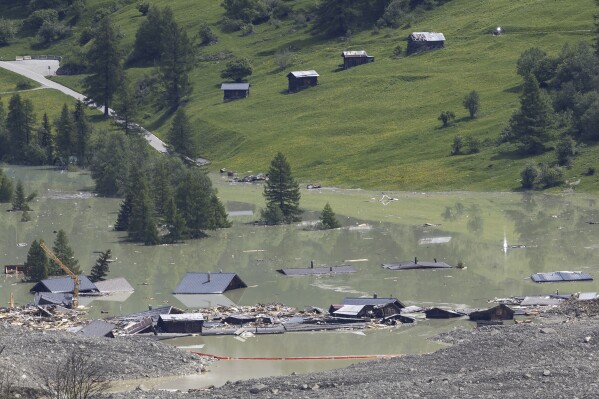 Check dams set up on the water from the Lonza river flows over the mud and stone, after the formation of a lake by the last houses of the village of Blatten, Switzerland, Saturday, May 31, 2025. (Cyril Zingaro/Keystone via AP)