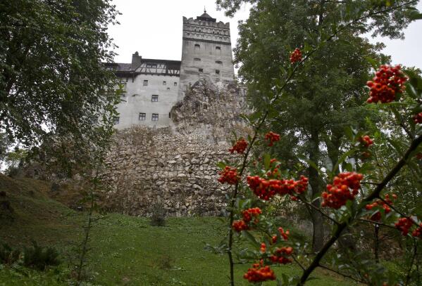 FILE - In this Saturday, Oct. 8, 2011 file picture, the Gothic Bran Castle, better known as Dracula Castle, is seen on a rainy day in Bran, in Romania's central Transylvania region. Romanian authorities have set up a COVID-19 vaccination center in a medieval building in Bran, not far from the castle, as a means to encourage people to vaccinate and also to boost tourism which has decreased in the area as a result of the pandemic. (AP Photo/Vadim Ghirda, File)