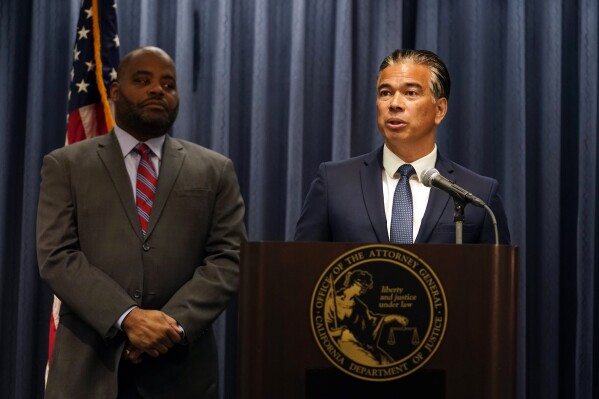 California Attorney General Rob Bonta, right, fields questions during a press conference Monday, Aug. 28, 2023, in Los Angeles. California's attorney general sued a Southern California school district Monday over its recently adopted policy that requires schools to notify parents if their children change their gender identification or pronouns. (AP Photo/Marcio Jose Sanchez)