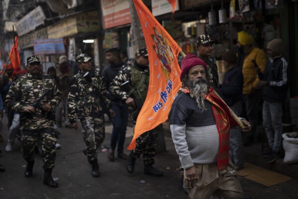 A Hindu man carries a flag featuring Hindu god Ram to celebrate the upcoming opening of a grand temple for the Lord Ram in northern Ayodhya city, during a procession in New Delhi, India, Tuesday, Jan. 16, 2024. (AP Photo/Altaf Qadri)