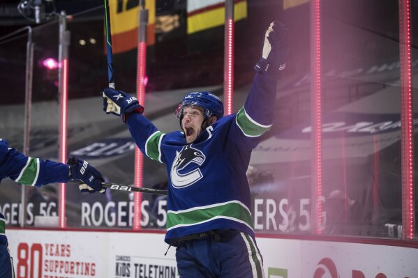 Vancouver Canucks' Bo Horvat celebrates after scoring the winning goal during overtime of an NHL hockey game against the Toronto Maple Leafs in Vancouver, British Columbia, Sunday, April 18, 2021. (Darryl Dyck/The Canadian Press via AP)