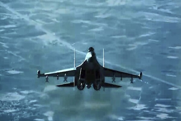 In this image from video released by the U.S. Air Force, a Russian fighter jet flies close to a U.S. drone over Syria, July 23, 2023. A Russian fighter jet flew within a few meters of a U.S. drone over Syria and fired flares at it, striking the American aircraft and damaging it, the U.S. military said Tuesday, the latest in a string of aggressive intercepts by Russia in the region. (U.S. Air Force via AP)