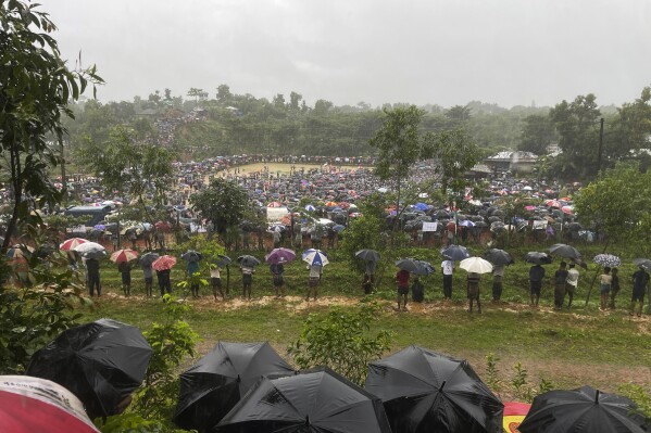 Hundreds of Rohingyas gather in the rain to demand safe return to Myanmar's Rakhine state as they mark the seventh anniversary of their exile from Myanmar at their refugee camp at Kutupalong in Cox's Bazar district, Bangladesh, Sunday, Aug. 25, 2024. (AP Photo/ Shafiqur Rahman)