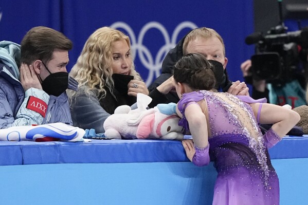 FILE - Coach Eteri Tutberidze, second left, talks to Kamila Valieva, of the Russian Olympic Committee, at a training session ahead of the women's short program during the figure skating at the 2022 Winter Olympics, Tuesday, Feb. 15, 2022, in Beijing. Russian figure skater Kamila Valieva has been disqualified from the 2022 Beijing Olympics. The verdict from the Court of Arbitration for Sport comes almost two years after Valieva's doping case caused turmoil at the Beijing Games. (APPhoto/David J. Phillip, File)